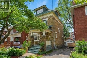 Ottawa apartment for rent - A house with a green roof and a tree in front.