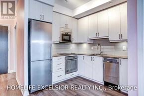 Toronto (Henry Farm) condo for rent - A kitchen with white cabinets and a stainless steel refrigerator.