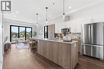 Windsor condo for rent - A modern kitchen with wooden cabinets and stainless steel appliances.