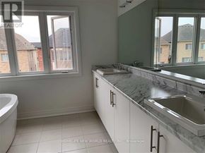 East Gwillimbury (Holland Landing) apartment for rent - A bathroom with a tub, sink, and window.