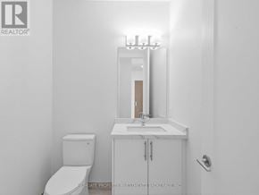 Vaughan (Vellore Village) condo for rent - A white bathroom with a toilet, sink and mirror.