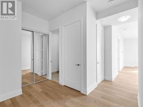 Vaughan (Vellore Village) condo for rent - A room with white walls and wooden flooring, with a sliding door and a white door.