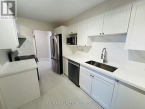 Toronto (Eringate-Centennial-West Deane) condo for rent - A white kitchen with a refrigerator, microwave, and sink.