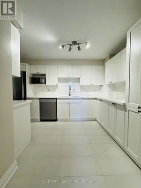 Toronto (Eringate-Centennial-West Deane) condo for rent - A kitchen with white cabinets and a black fridge.