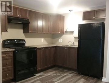 Huntsville (Chaffey) triplex for rent - A kitchen with a black refrigerator and stove.