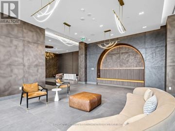 Vaughan (Vellore Village) condo for rent - A modern living room with a curved sofa and a circular light fixture.