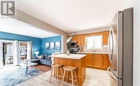 Kitchener apartment for rent - A kitchen with a refrigerator, a bar stool, and a dining table.