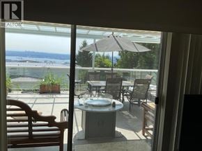 West Vancouver apartment for rent - A patio with a table and chairs overlooking a lake.