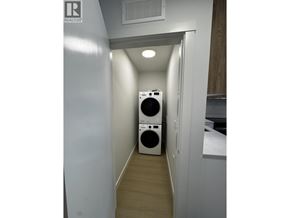 New Westminster apartment for rent - A laundry room with a washer and dryer stacked on top of each other.