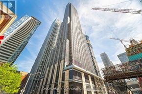 Toronto (Annex) condo for rent - A tall building under construction with cranes around it.