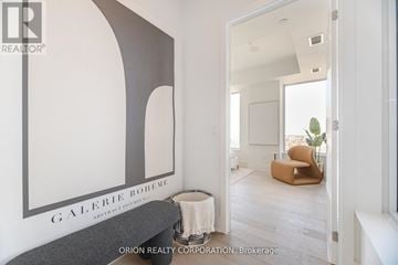 Toronto (Annex) condo for rent - A living room with a couch and a painting of a white chair.