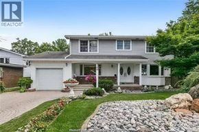 Windsor apartment for rent - A house with a grey roof and white walls is surrounded by a garden with a stone pathway leading to the front door.