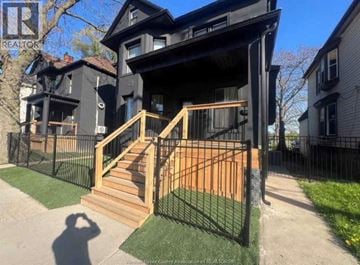 Windsor apartment for rent - A black house with a wooden staircase leading to the front door.