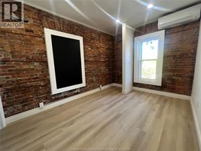 Windsor apartment for rent - A room with a brick wall and wooden flooring.