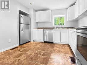 Renfrew apartment for rent - A kitchen with white cabinets and brown tiled flooring.