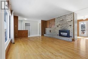 Ottawa apartment for rent - A spacious living room with a stone fireplace and wooden floors.
