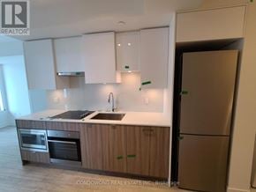 Toronto (Mount Pleasant West) condo for rent - A kitchen with white cabinets and a wooden island with a sink and oven.