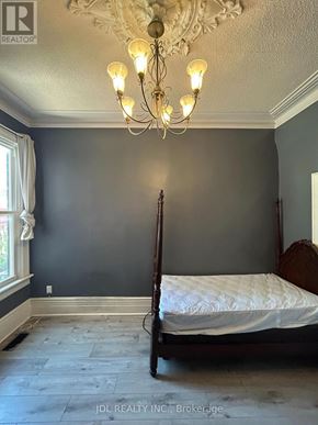Toronto (Kensington-Chinatown) apartment for rent - A bedroom with a four poster bed and a chandelier.