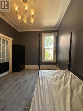 Toronto (Kensington-Chinatown) apartment for rent - A bedroom with a bed, window, and chandelier.