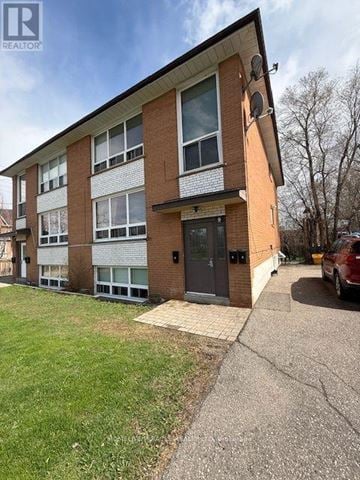 Mississauga (Streetsville) multi-family for rent - A building with a brown and white facade has a black door and windows.