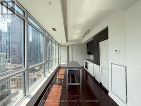 Toronto (Waterfront Communities) condo for rent - A long, narrow apartment with a view of the city outside the large windows.
