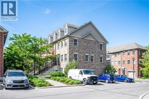 Kitchener townhouse for rent - A street view with cars and a building with the REALTOR® logo.