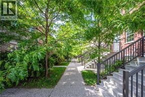 Kitchener townhouse for rent - A tree-lined walkway with a metal railing on the right side.