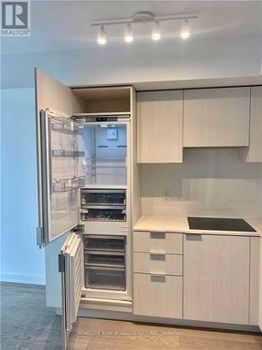 Toronto (Bay Street Corridor) condo for rent - A modern kitchen with a refrigerator and cabinets.