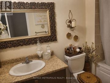 Pickering (Duffin Heights) townhouse for rent - A bathroom with a sink, toilet, and mirror.