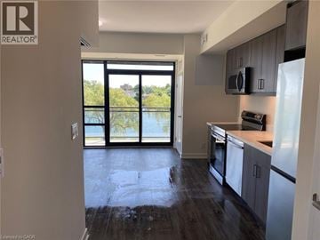 Welland condo for rent - A kitchen with a refrigerator, microwave, and oven.
