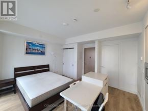 Toronto (Waterfront Communities) condo for rent - A bedroom with a bed, desk, and chair.