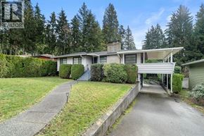 North Vancouver apartment for rent - A house with a driveway and a garage is surrounded by trees.