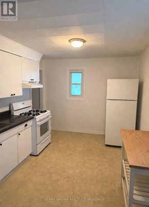 Welland (Lincoln/Crowland) apartment for rent - A kitchen with white cabinets and a black stove top.