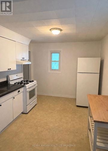 Welland (Lincoln/Crowland) apartment for rent - A kitchen with white cabinets and a black stove top.