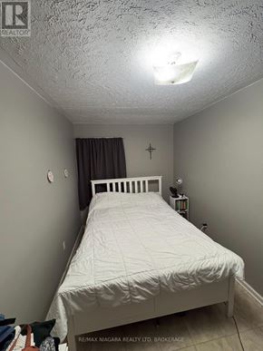Welland (Lincoln/Crowland) apartment for rent - A bedroom with a white bed and a cross on the wall.