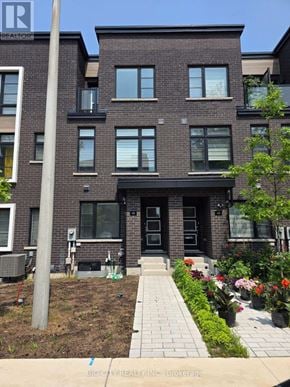 Toronto (Bendale) townhouse for rent - A brick building with a black front door and windows.