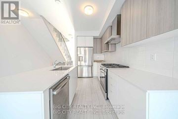 Toronto (Bendale) townhouse for rent - A modern kitchen with white cabinets and appliances.