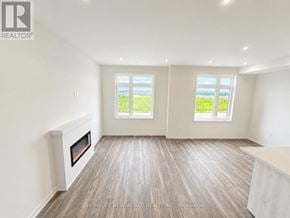 Richmond Hill townhouse for rent - A spacious room with a fireplace and two windows overlooking a green field.