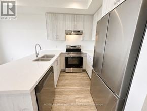 Richmond Hill townhouse for rent - A modern kitchen with white cabinets and a stainless steel refrigerator.