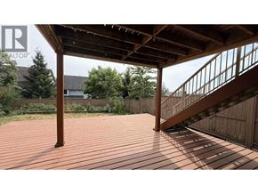 Coquitlam apartment for rent - A wooden deck with a staircase leading to a house.