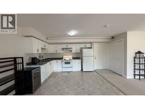 Coquitlam apartment for rent - A kitchen with a black counter top and white cabinets.