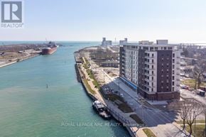Port Colborne (Sugarloaf) condo for rent - A view of a river with a boat and a building on the right side.
