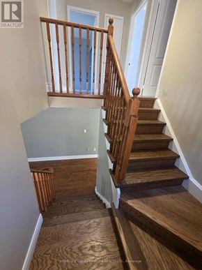 Ajax (Northeast Ajax) apartment for rent - A wooden staircase with a white wall on the side.