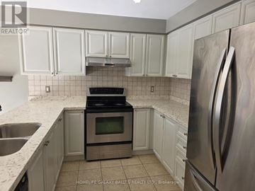 Ajax (Northeast Ajax) apartment for rent - A kitchen with white cabinets and a stainless steel refrigerator.
