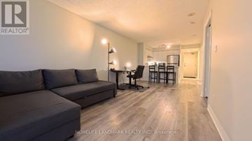 Toronto (Bayview Village) condo for rent - A living room with a grey couch and a wooden floor.
