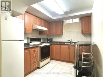 Markham (Milliken Mills East) apartment for rent - A kitchen with brown cabinets and a white refrigerator.
