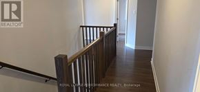 Ottawa apartment for rent - A hallway with a wooden railing and a white wall.