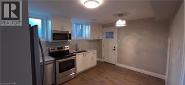 Kitchener apartment for rent - A kitchen with a stove top oven and a refrigerator.