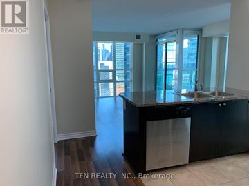 Toronto (Waterfront Communities) condo for rent - A kitchen with black cabinets and a dishwasher is shown.