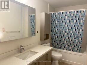 Markham (Unionville) condo for rent - A bathroom with a sink, toilet, and shower curtain.